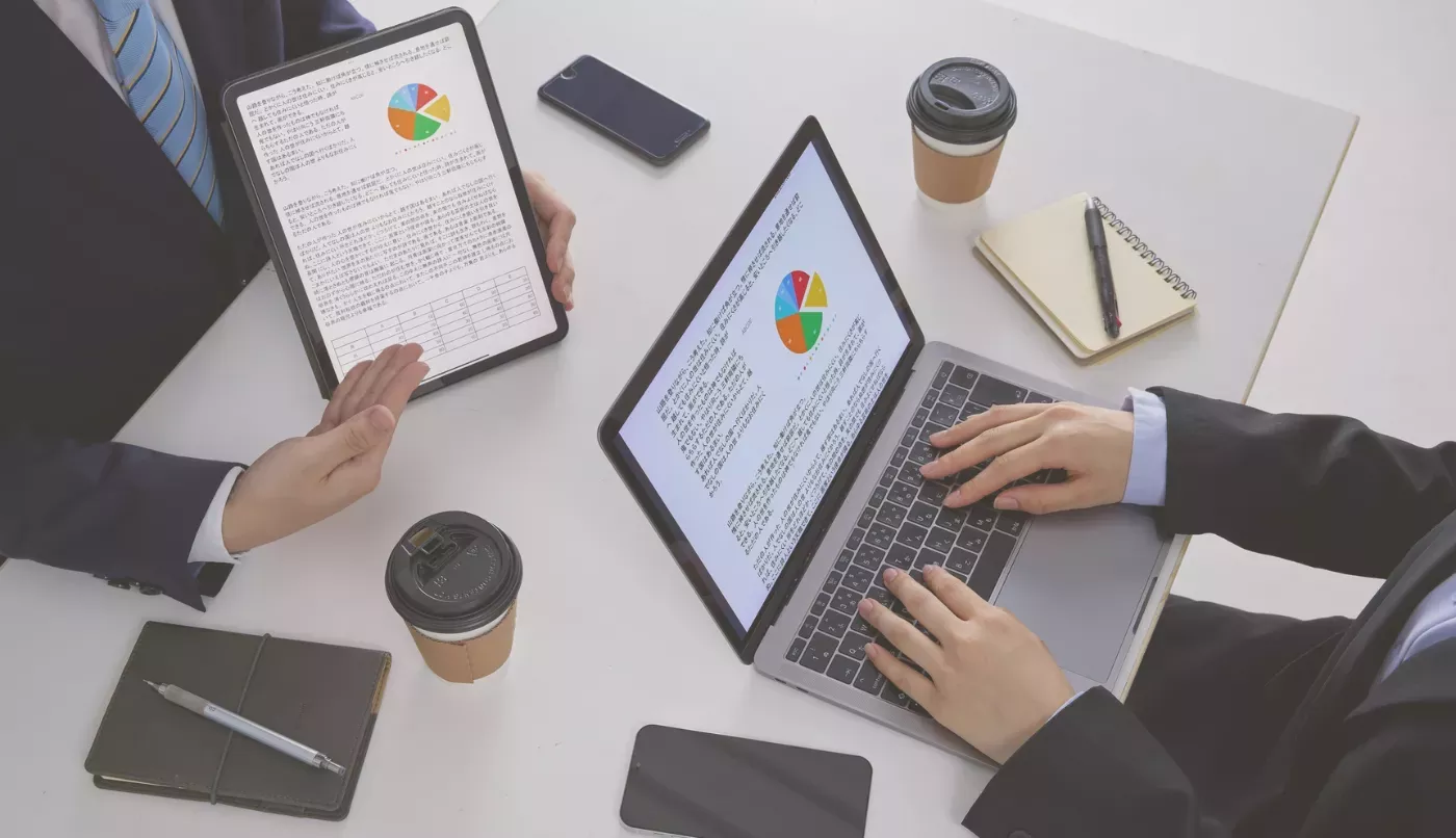 Business team reviewing performance charts on laptops and a tablet